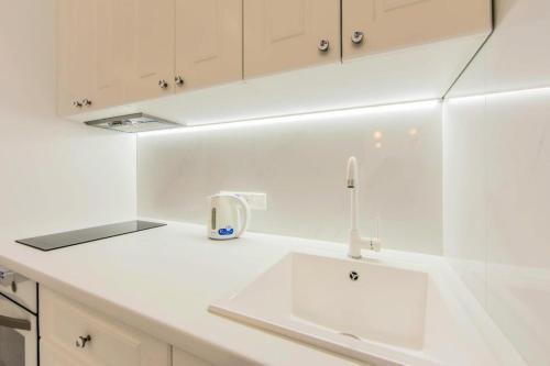 una cucina con piano di lavoro bianco e lavandino di 1 room 50m2 center of Obolon near River side. Smart Plaza a Kiev