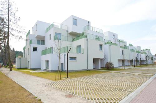 Un gran edificio blanco con muchas ventanas. en Apartamenty Lux Pogorzelica, dwupoziomowy, dwie łazienki, dwa tarasy, pies gratis!, en Pogorzelica