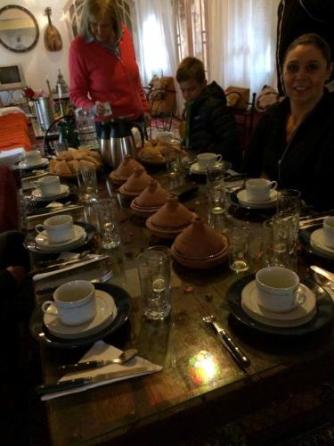 a group of people sitting around a table with food at Chez Kossai Atlas Farm in Chtawna
