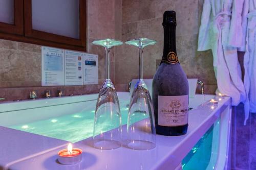 een fles wijn en twee glazen in een bad bij BED & SPA - LA PARENTHESE Topdestination-Dijon - Centre ville - classé 3 étoiles in Dijon