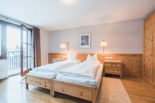 a bedroom with a large bed and a large window at Felbermayer Hotel & AlpineSpa-Montafon in Gaschurn