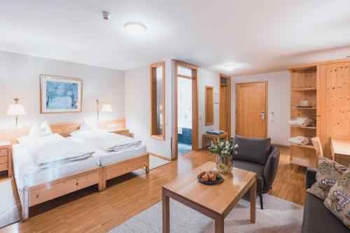a bedroom with a bed and a living room at Felbermayer Hotel & AlpineSpa-Montafon in Gaschurn