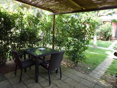 a black table and chairs under a pergola at Agrialbergo Capalbio La Sugherella in Capalbio