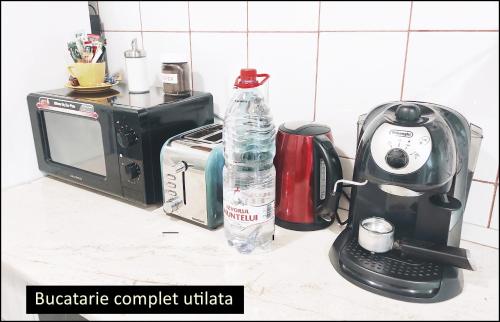 um balcão de cozinha com um micro-ondas e uma garrafa de água em Smart Apartament em Piatra Neamţ