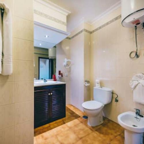 a bathroom with a toilet and a sink at Sunshine Apartments in San Miguel de Abona