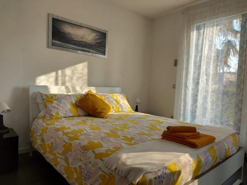 um quarto com uma cama com um cobertor amarelo e uma janela em Casa Viola Vicenza Park Free em Vicenza