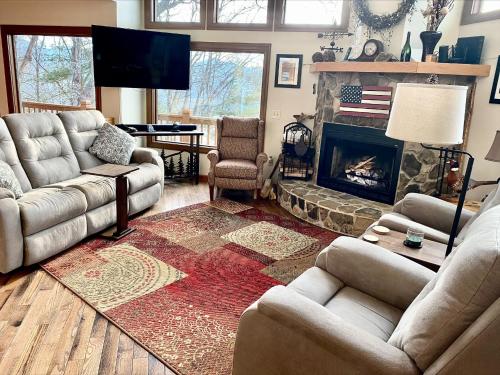 a living room with a couch and a fireplace at Bear's Mountaintop Home with Gorgeous Lake Views chalet in Santeetlah