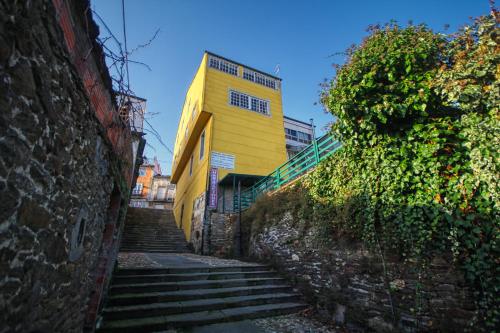 a yellow building with stairs leading up to it at Pension Escalinata in Sarria