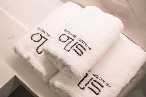 a pile of white towels sitting on a shelf at Silo Luxury Rooms in Nafplio