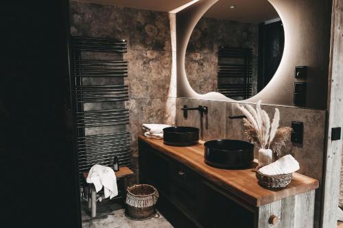 a bathroom with a sink and a mirror at Jufenalm BOHO & Wellnesshotel in Maria Alm am Steinernen Meer