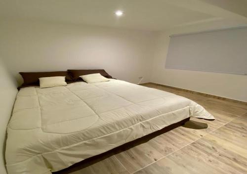 a bedroom with a large white bed in a room at Habitaciones tipo hotel con terraza in Ibagué