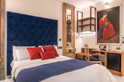 a bedroom with a blue headboard and a bed with red pillows at Silo Luxury Rooms in Nafplio