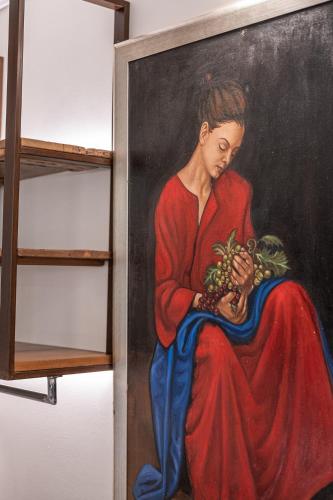 a painting of a woman holding a bunch of grapes at Silo Luxury Rooms in Nafplio
