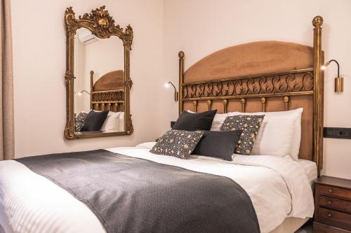 a bedroom with a large bed and two mirrors at Silo Luxury Rooms in Nafplio