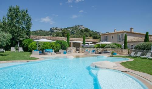 une piscine dans une cour avec des chaises et une maison dans l'établissement Mas de l'Oulivié, aux Baux-de-Provence