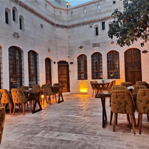 un cortile con tavoli e sedie in un edificio di Tessera Hotel a Şanlıurfa