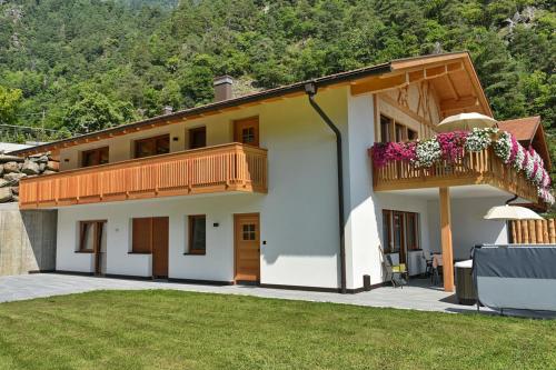 a house with a balcony with flowers on it at Residence Blumenthalerhof in Lagundo
