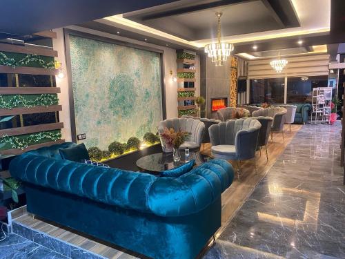a lobby with a blue leather couch and chairs at Grand Zara Hotel in Kayseri