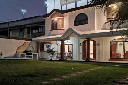 a house with a lawn in front of it at HERMOSA CASA EN CUERNAVACA: JARDÍN DEL LAGO in Cuernavaca