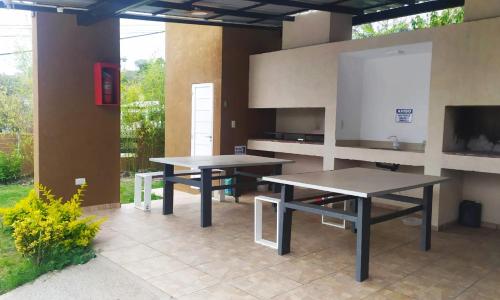 two picnic tables in a patio with a tv at By Muni Apartamentos Premium in Tanti