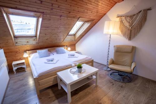 1 dormitorio con 1 cama, 1 silla y 1 mesa en Penzion Sofinata & Trattoria Lucio Špindlerův Mlýn, en Špindlerův Mlýn