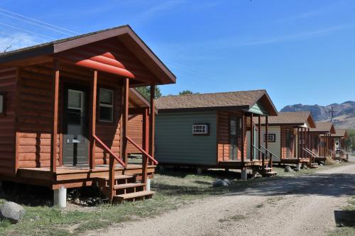 a row of wooden cabins on the side of a dirt road at Eycat Lodging Company in Wapiti
