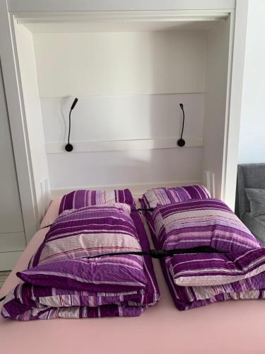 a bed with purple pillows on top of it at Holiday 88 in Leukerbad