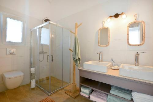 een badkamer met twee wastafels en een douche bij Villa Siga - Siga in Kokkínion