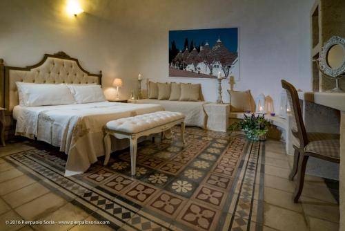 a bedroom with a bed and a couch at Masseria Cappuccini in Ostuni