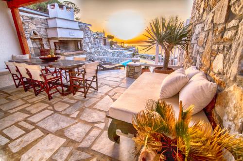 eine Terrasse mit einem Sofa, einem Tisch und Stühlen in der Unterkunft Villa Aqualis in Mykonos Stadt