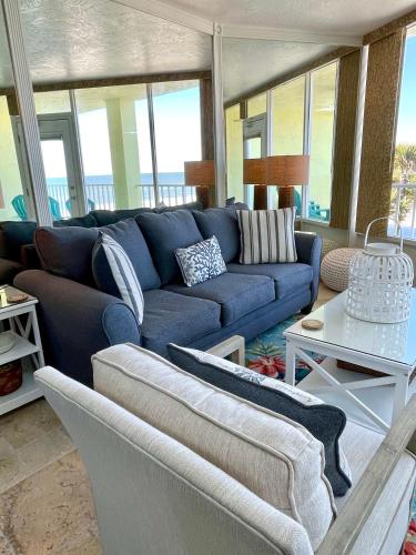 a living room with a blue couch and a table at Sea Dreams - Beachside 1 bedroom at Symphony Beach in Ormond Beach