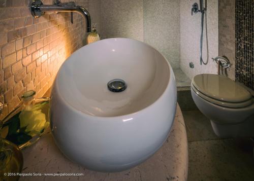 a white sink in a bathroom with a toilet at Masseria Cappuccini in Ostuni