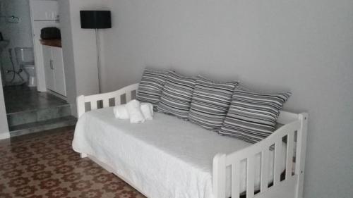 Una cama blanca con dos almohadas encima. en Apartamento-Loft, en Mercedes