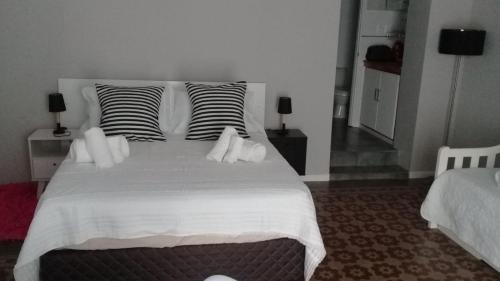 1 dormitorio con 1 cama blanca grande y 2 almohadas en Apartamento-Loft en Mercedes