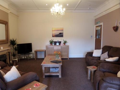 a living room with two couches and a tv at Beecroft Lodge in Paignton