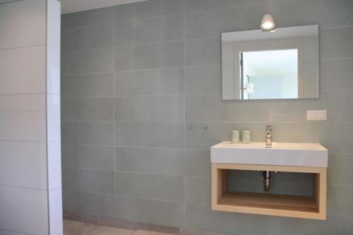 a bathroom with a sink and a mirror at Callant's Oog in Callantsoog