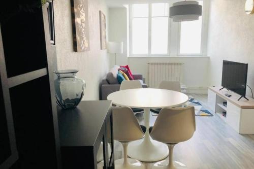 un salon avec une table et des chaises blanches dans l'établissement Superbe Appart 2 lits Style Contemporain, à Nancy