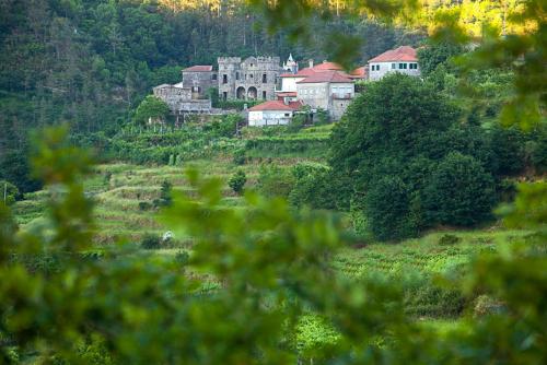 un grupo de casas en una colina con árboles en Férias de Sonho, en Arcos de Valdevez