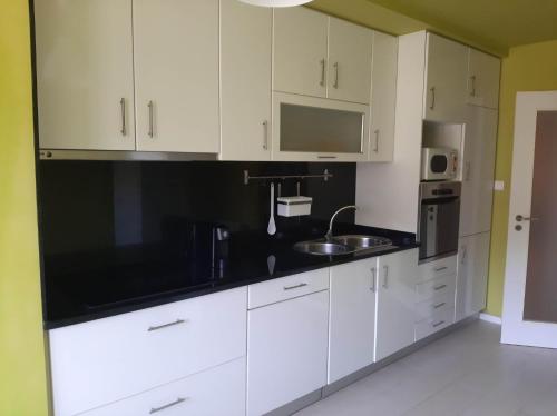 a kitchen with white cabinets and a sink at Férias de Sonho in Arcos de Valdevez