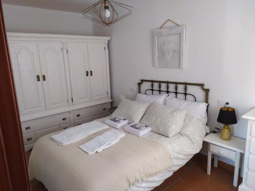 埃爾博斯克的住宿－Casa Curro，卧室配有白色的床和2条毛巾