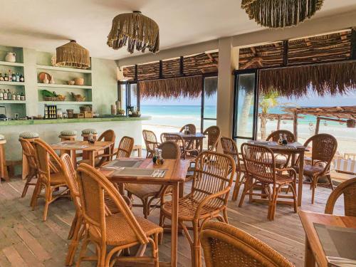 a restaurant with tables and chairs and a view of the beach at Dune Boutique Hotel located at the party zone in Tulum