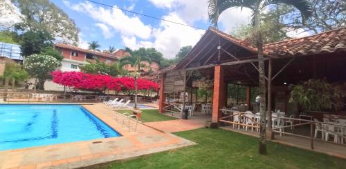 a villa with a swimming pool and a house at Hotel Campestre UMPALÁ in San Gil
