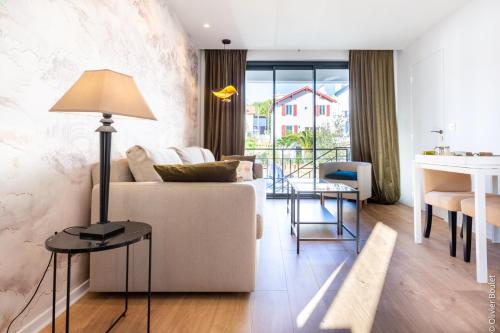 uma sala de estar com um sofá e uma mesa em VILLA BIBI CHERI Elégante Suite de 35 M2 em Biarritz