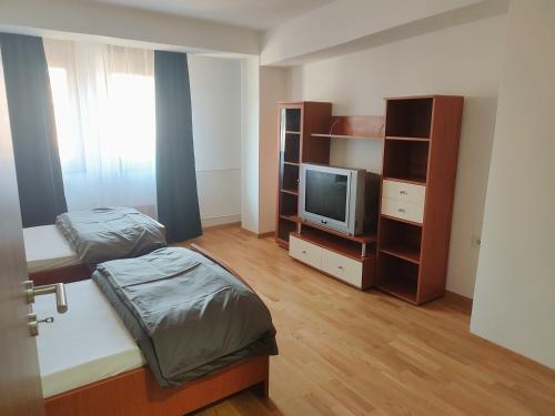 a small room with two beds and a tv at Antoni Apartment in Skopje