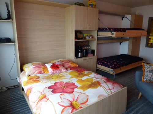 a bedroom with a bed with a floral bedspread at Zeezicht Studio Alisa in Blankenberge