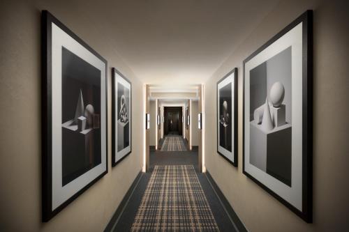 a hallway with a row of framed art on the walls at Hyatt Regency San Francisco Downtown SOMA in San Francisco