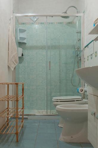 a bathroom with a toilet and a glass shower at La Casa del Limoneto in Favignana