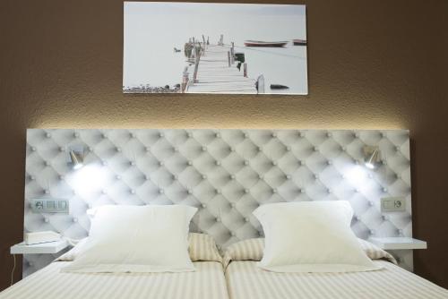 
a hotel room with a bed and two lamps at Hotel Avenida in Benicàssim
