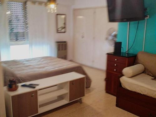 1 dormitorio con cama, sofá y TV en Leanja1 en Mar del Plata
