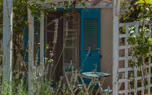 a blue door in a garden with a table at La Casa del Limoneto in Favignana